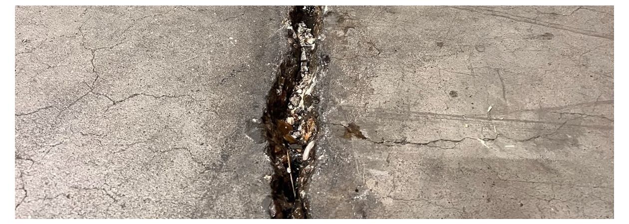 Ein Betonboden mit einem großen Riss, der repariert werden muss.